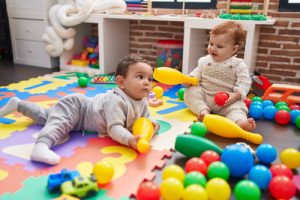 two-adorable-babies-playing-with-balls-bowling-pin-sitting-floor-kindergarten (1)